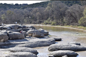 Large grey boulders sit along a riverbed at Big Rocks Park in the Paluxy River