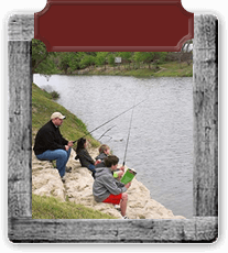 Wooden frame around a photo of a man and three children fishing in the river.