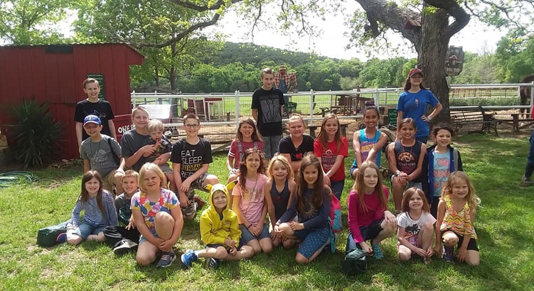 A group of homeschool kids taking a group picture holding bunnies.