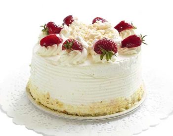 A cake frosted in white with crumb and strawberry decorations.